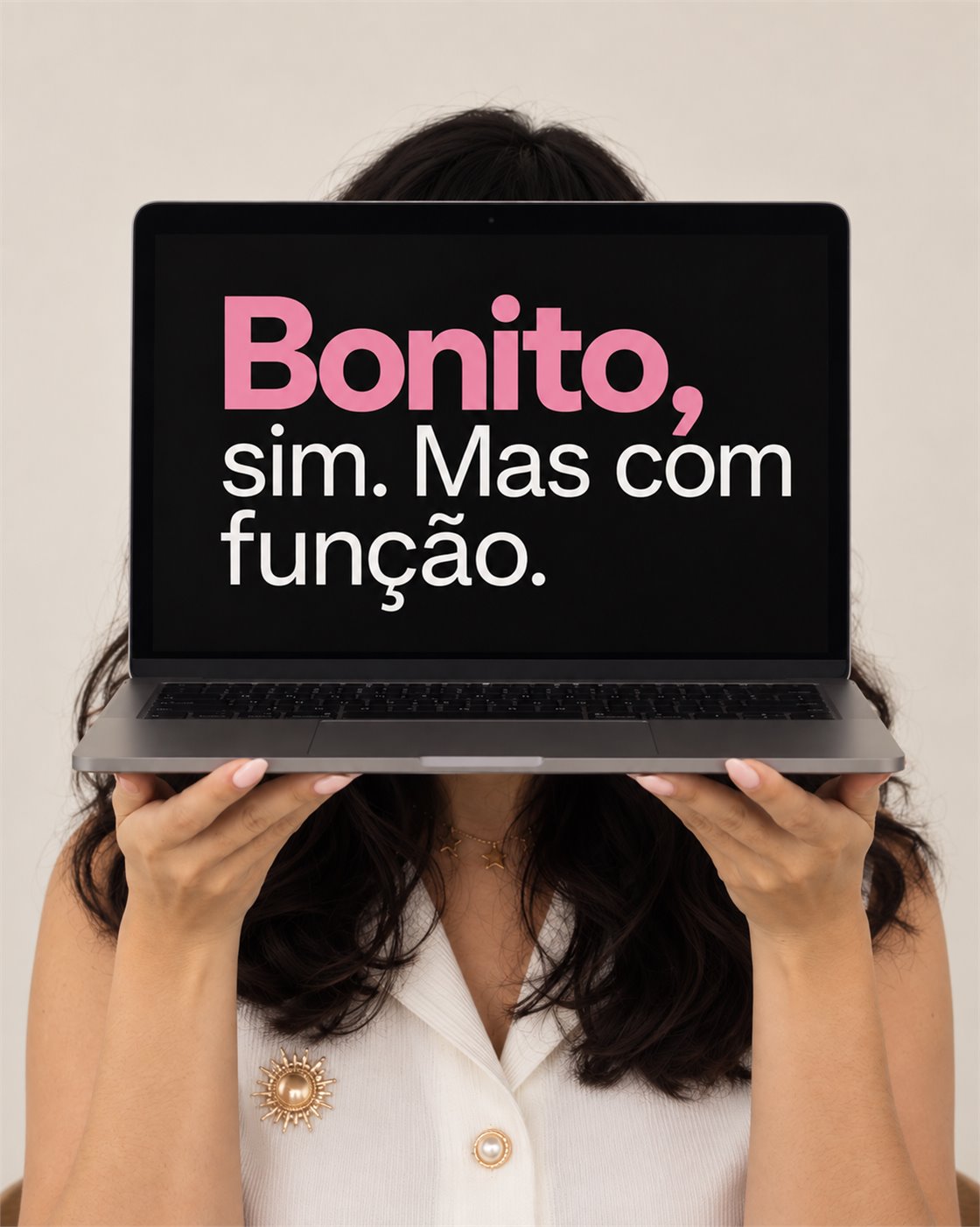 Julia segurando um notebook à frente do rosto; na tela lê-se: Bonito, sim. Mas com função.